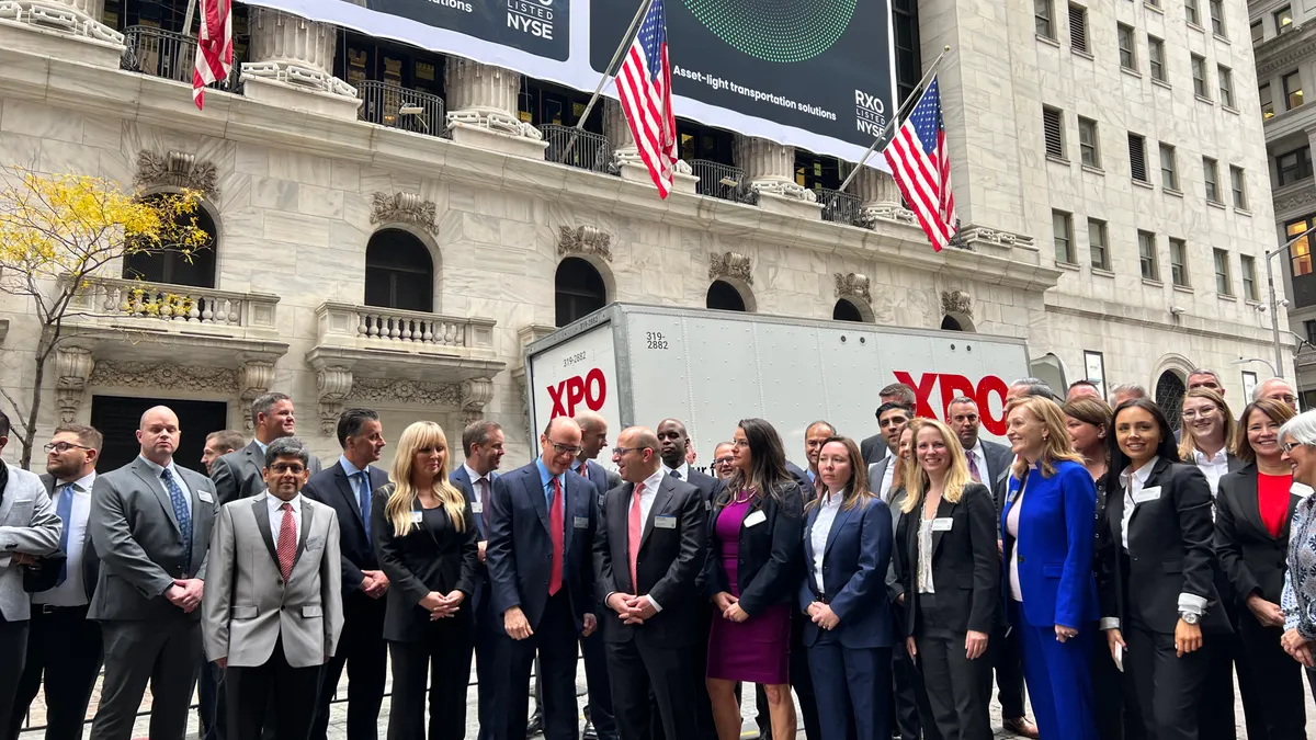 XPO Logistics founder Brad Jacobs and Mario Harik talk between photos with colleagues in front of the New York Stock Exchange on the day of the Nov. 1 spinoff of RXO, the company's brokerage arm.