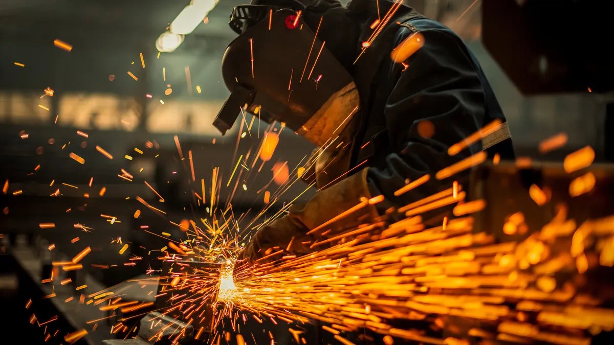 Metal worker using a grinder