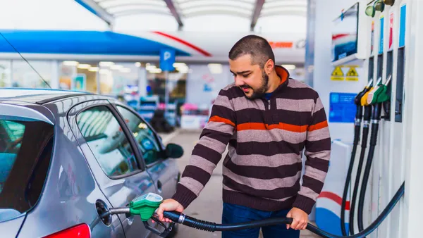 A person filling up their car at a gas pump.