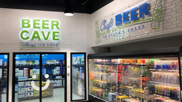 A photo of a beer cave and beverage cooler. Signs on the wall read "read cave always ice cold" and "craft beer to savor and share."