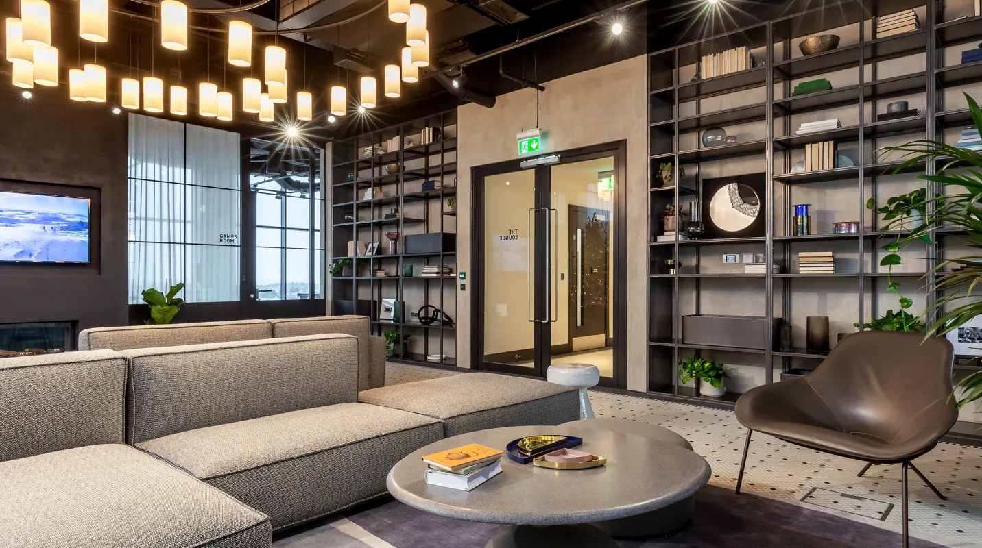 A lounge room with lots of shelving and couches. The glass door to the room is labeled "The Lounge."