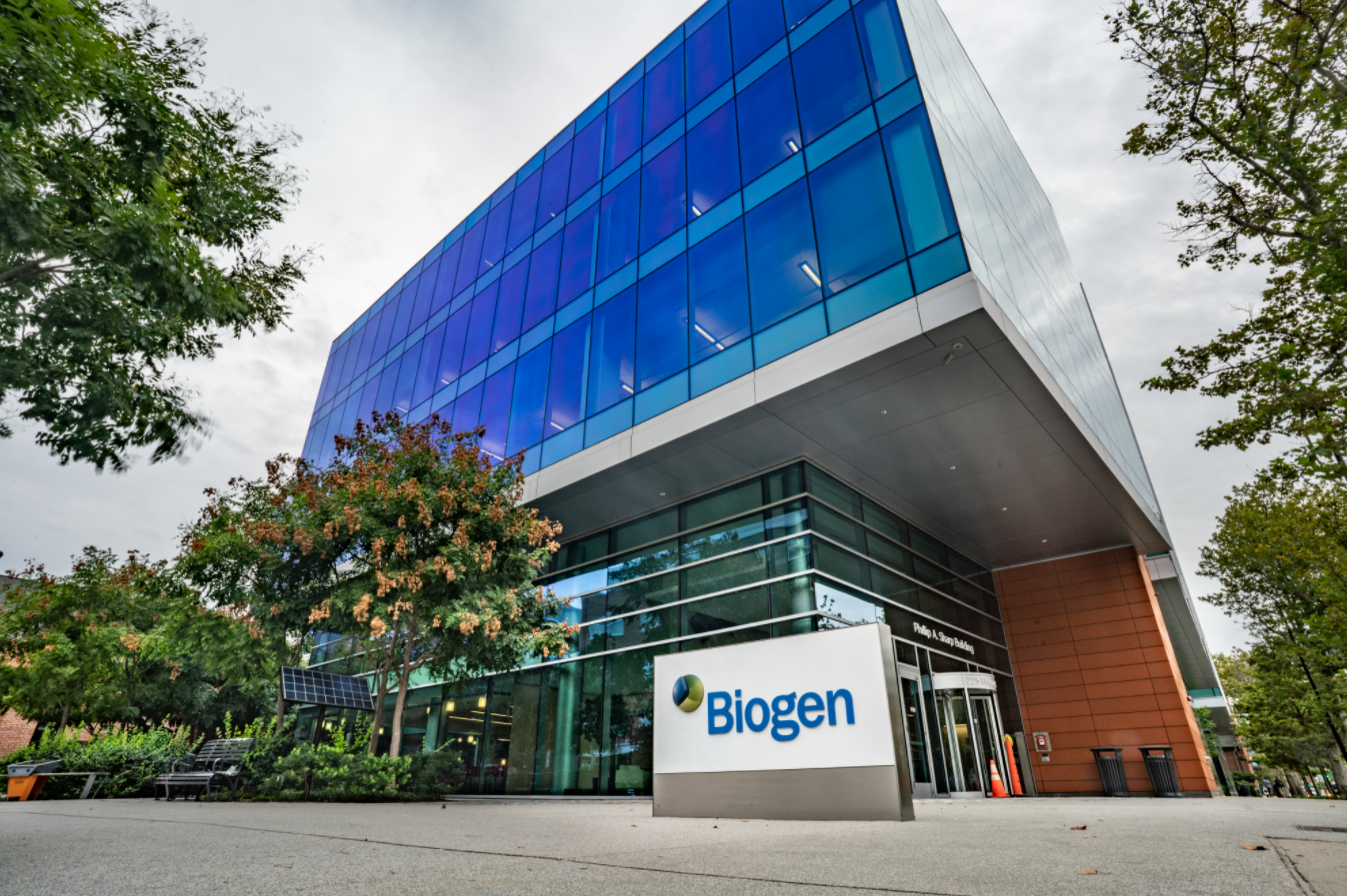 A sign showing Biogen's logo outside of an office building.