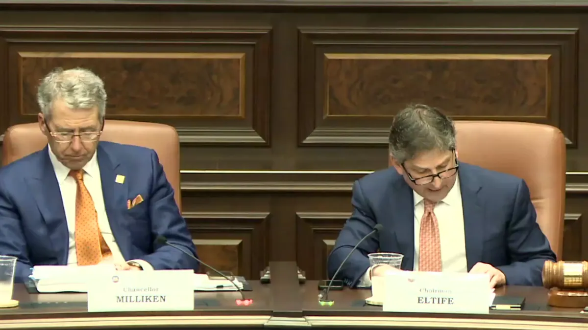 The chancellor of the University of Texas System, James Milliken, sits with the chair of its board, Kevin Eltife, who reads a statement about diversity policies.