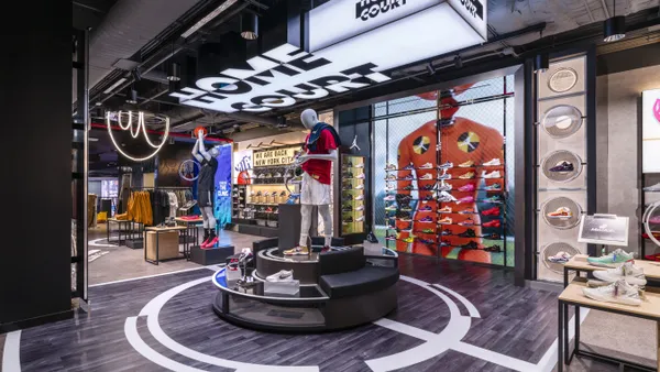 A store display featuring basketball-style flooring and mannequins, with walls of basketball shoes and "Home Court" written on the ceiling.