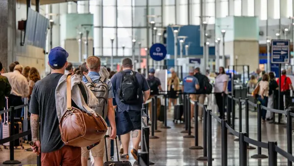 Travelers wait in line at an airport.