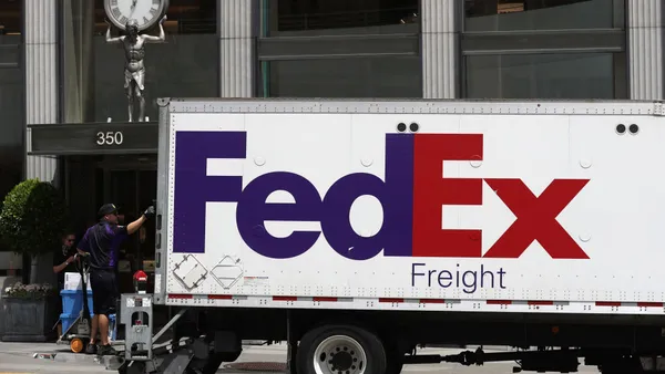 A FedEx Freight driver stands on the liftgate of his trailer in San Francisco, California, on June 25, 2019.