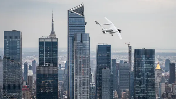Airplane flies over tall buildings.