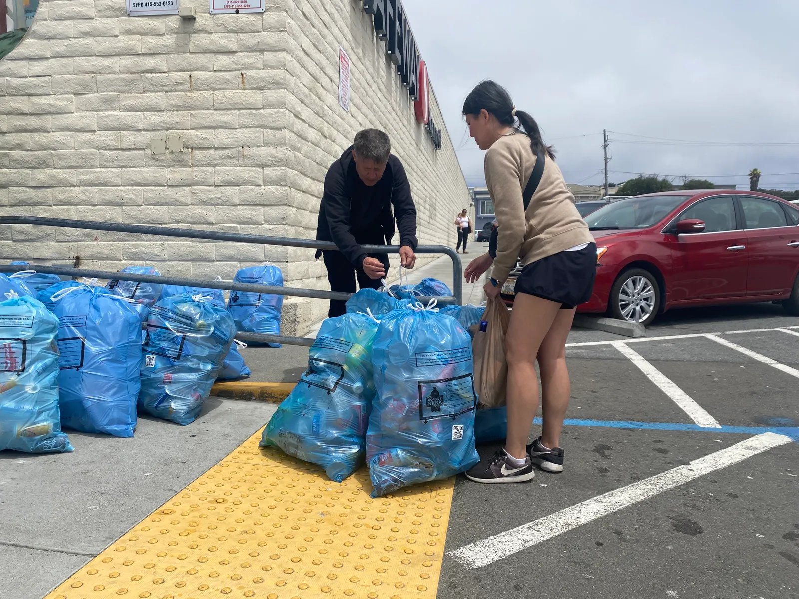 A shopper drops off a bag of recycling