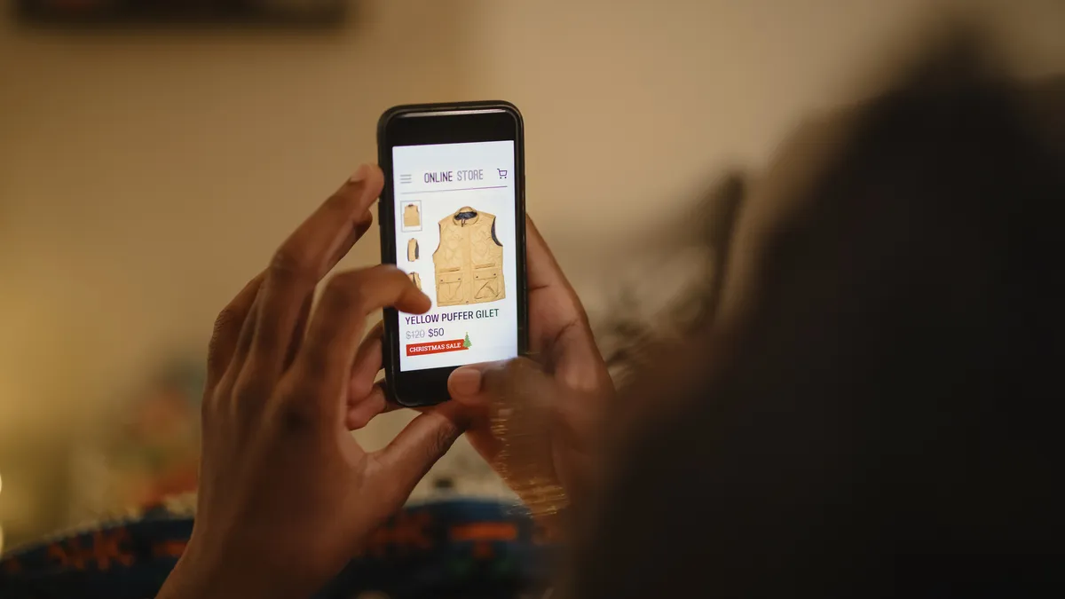 A person holds a mobile phone with a screen that has a vest on it.