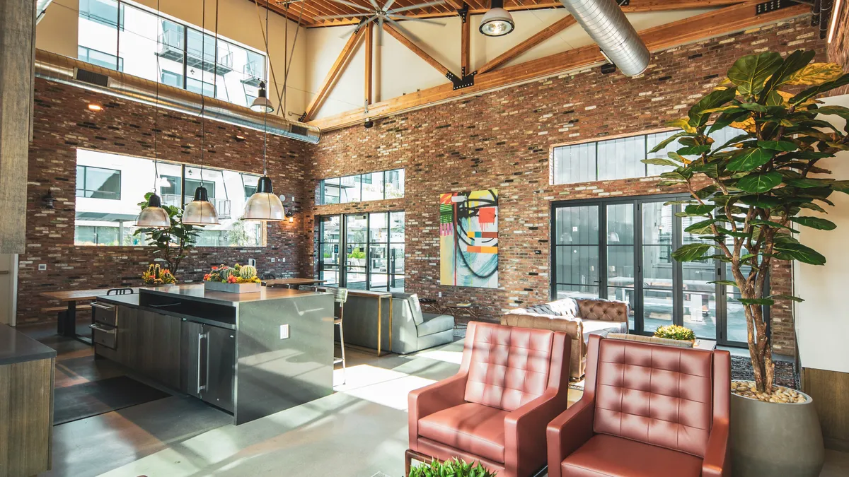 A lounge space with lots of seating and a kitchen counter.