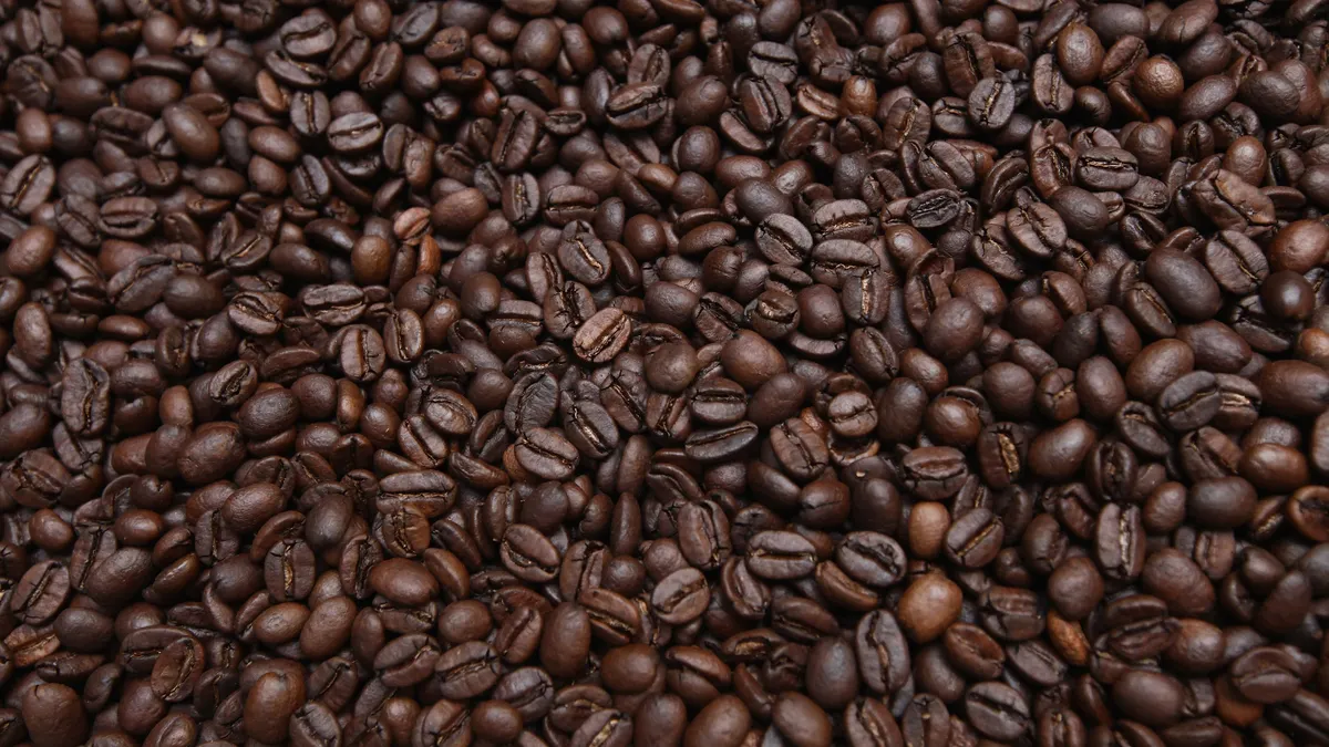 Roasted coffee beans fill the frame.