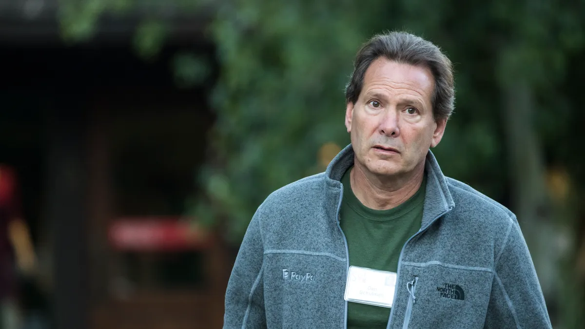 PayPal CEO Dan Schulman walking in front of trees