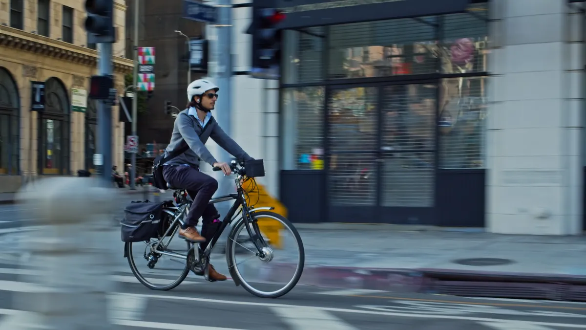 A man riding an e-bike in a city.