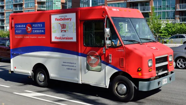 A Canada Post delivery truck on the road.