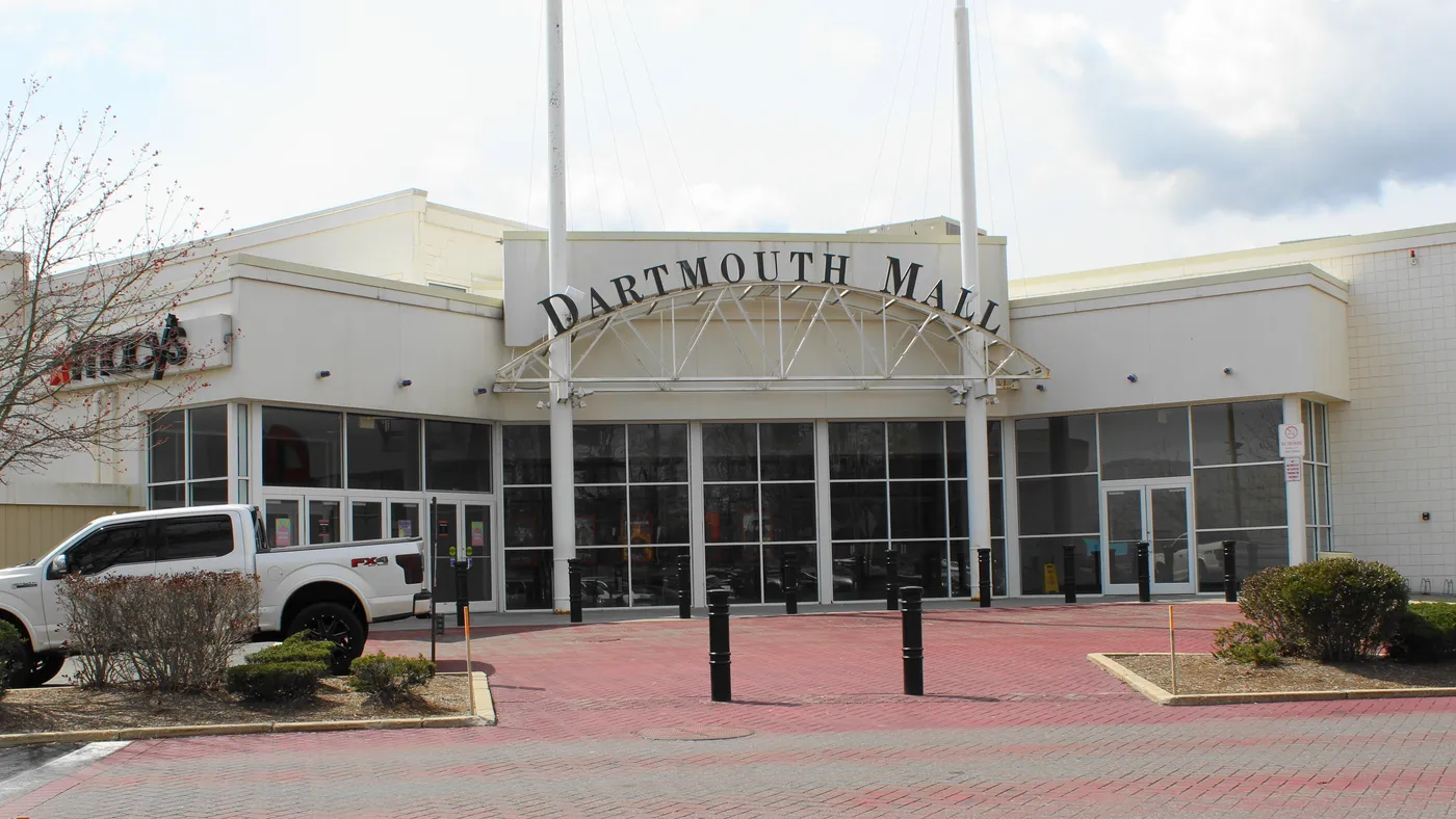 The entrance to a mall, with a white pickup truck parked to the right.