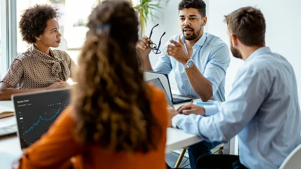 Professionals have a meeting in front of a computer.