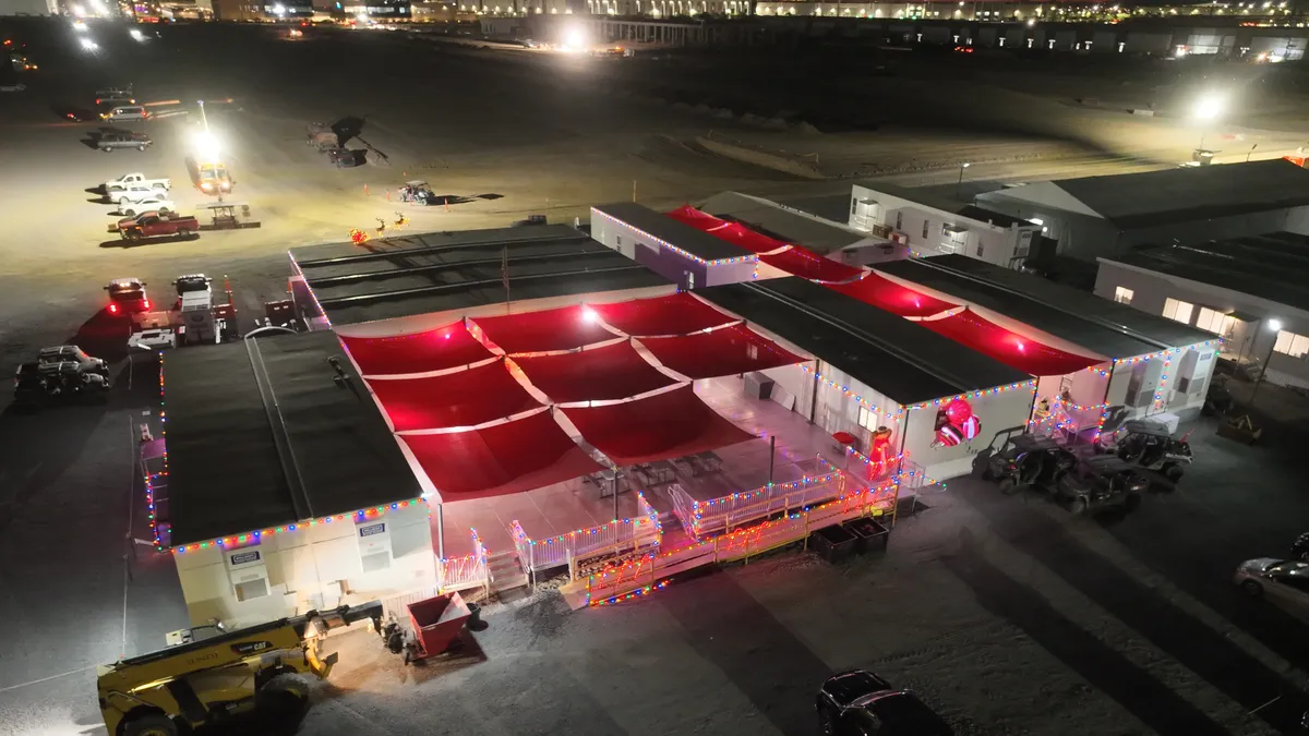 An overhead shot of an office in a dark parking lot. It's lit up in red lights.