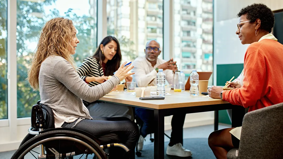Corporate professionals sitting around conference table and discussing ideas for project development.