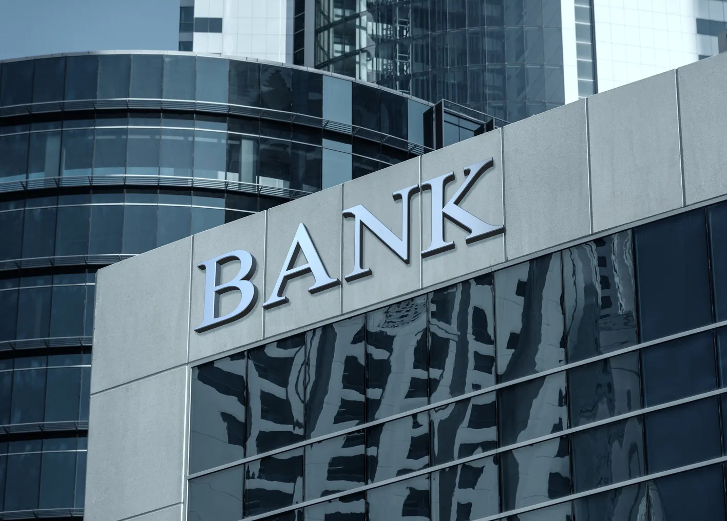 Bank sign on glass wall of business center.