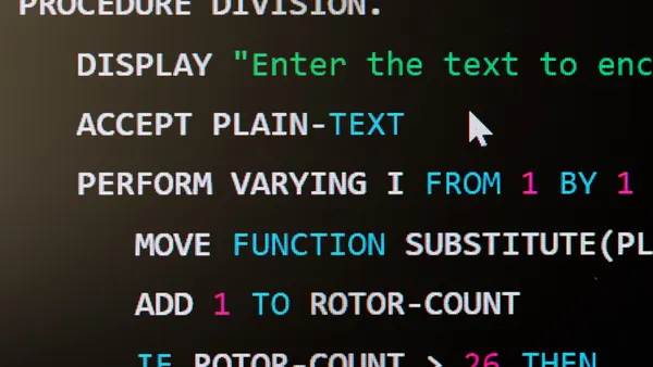 A computer screen displays a snippet of legacy COBOL programming language code.