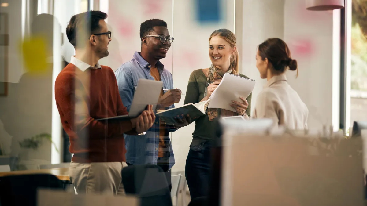 Coworkers standing and laughing with each other