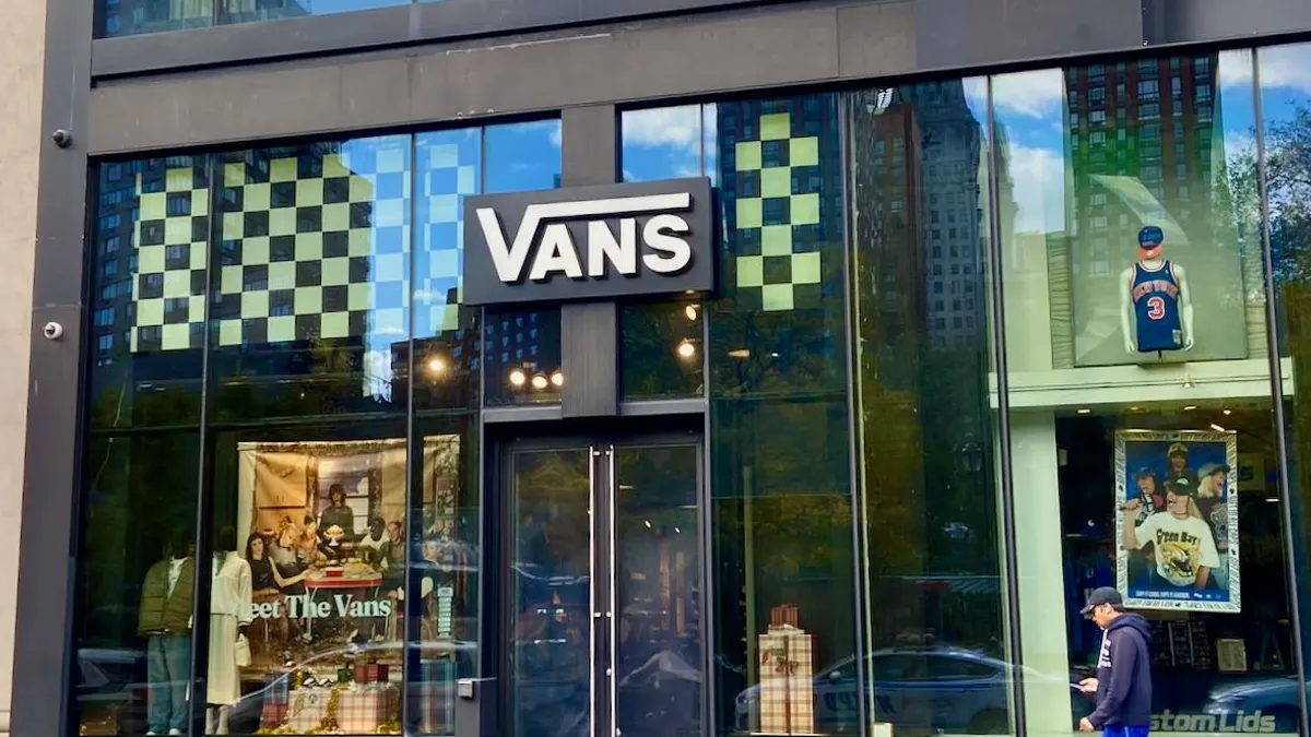 A person wearing sweats and a baseball cap walks down the street.