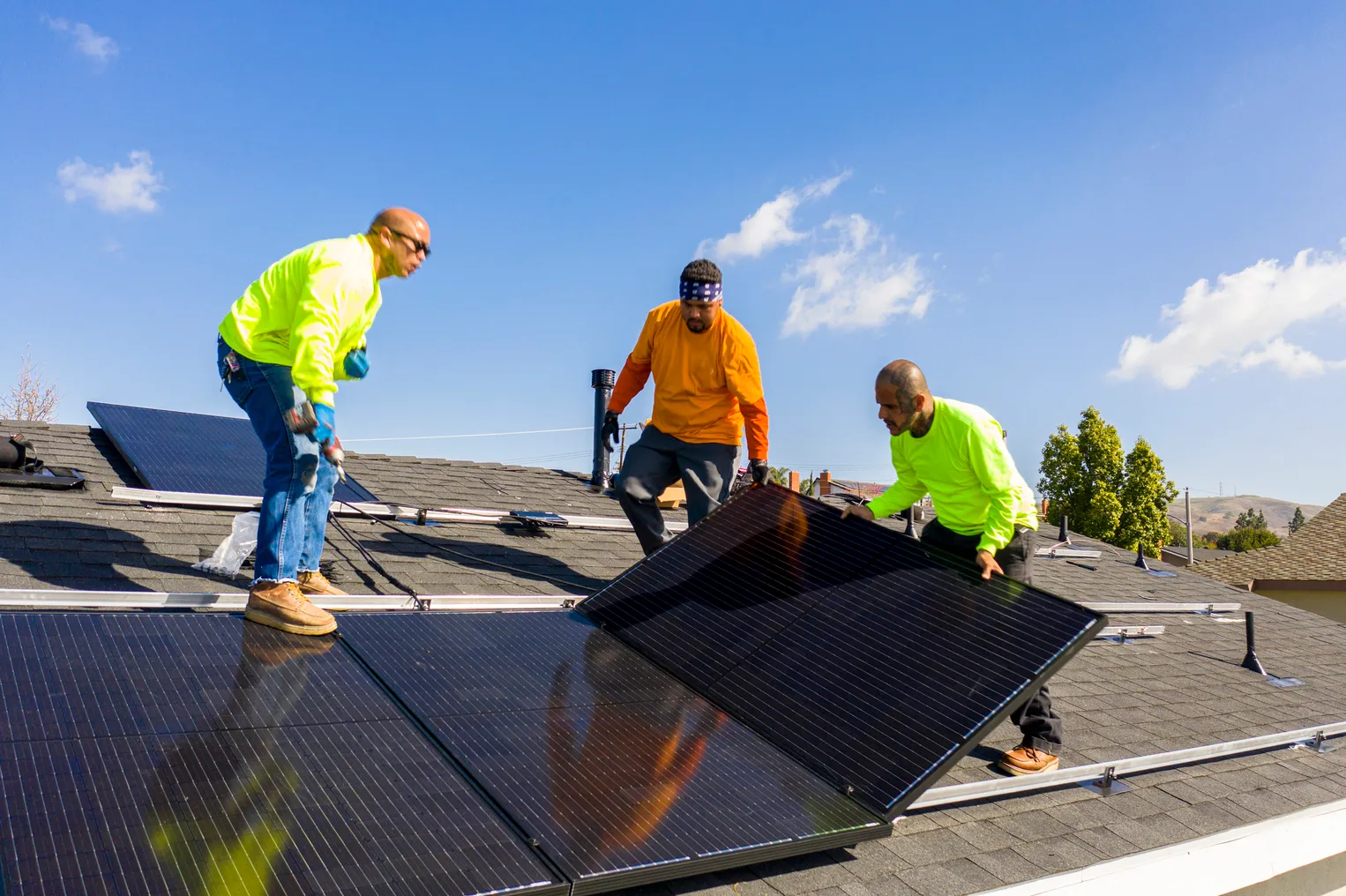 Team of workers install rooftop solar.