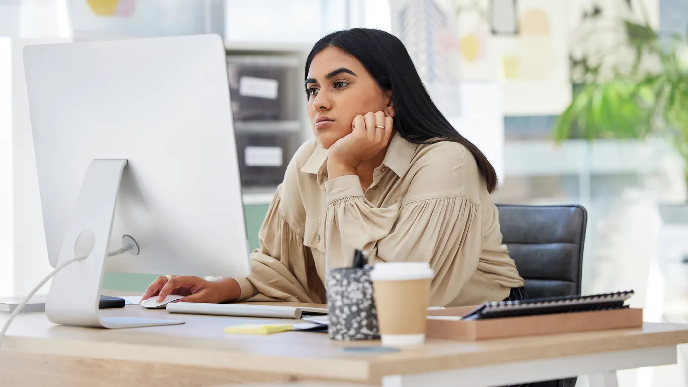Tired employee working on a computer in the office leaning
