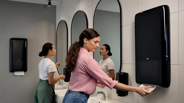 Women in a public bathroom freshening up