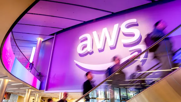 Attendees pass an AWS logo during the AWS re:Invent 2025 conference at The Venetian Convention and Expo Center on Dec. 2, 2025 in Las Vegas.