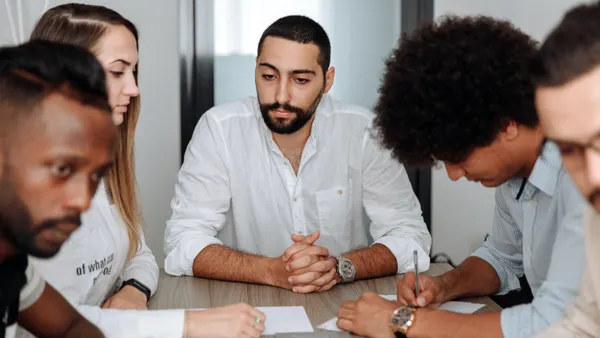 A Middle Eastern man in his 30s is deep in thought in his meeting