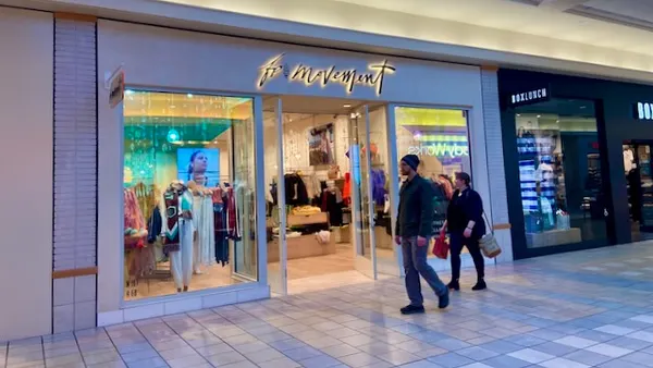 People walking past a mall store.