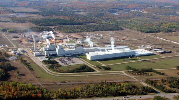 A wide exterior shot of an industrial facility surrounded by green space.