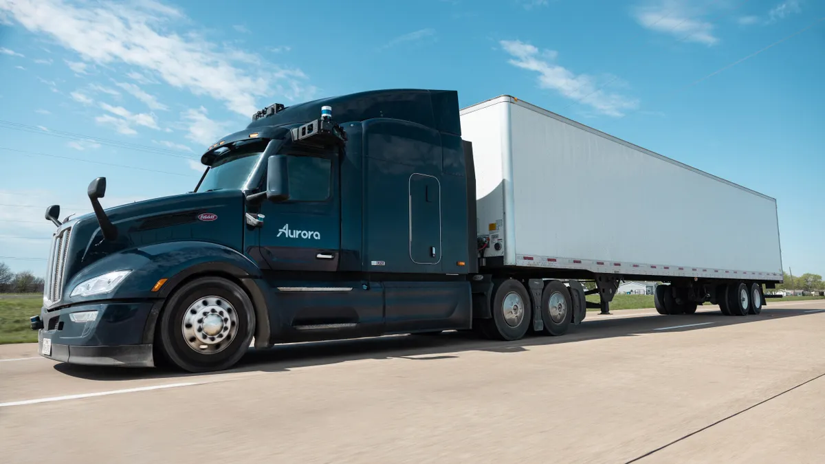 A Peterbilt truck, hauling a trailer, equipped with Aurora's autonomous driving technology.