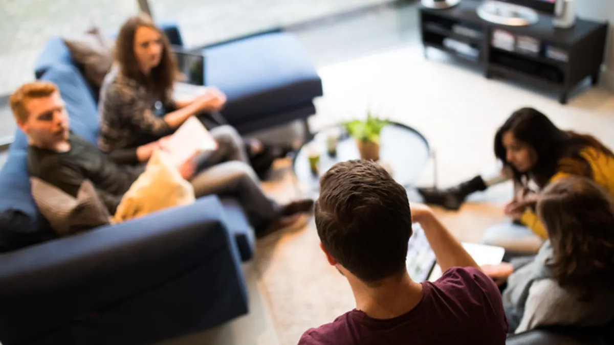 college students gather in an apartment living room