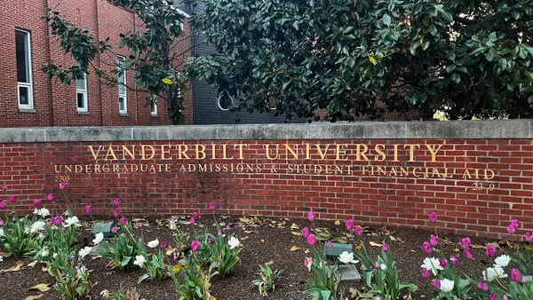A brick sign that reads "Vanderbilt University undergraduate admissions & financial aid" with tulips in the foreground.