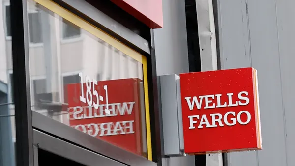 A sign reads "Wells Fargo" outside of a Wells bank branch.