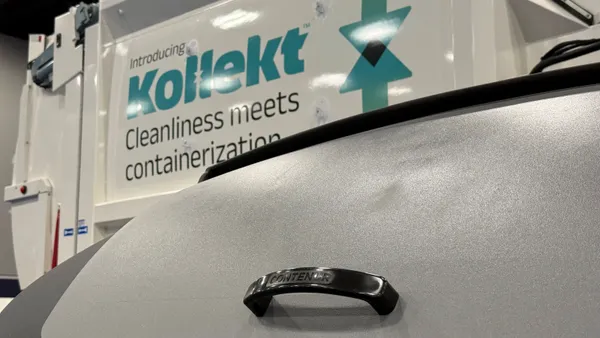 A large bin with a lid and a handle that reads "Contenur" is in the forgeround, while a truck with branding for "Kollekt" is behind it.