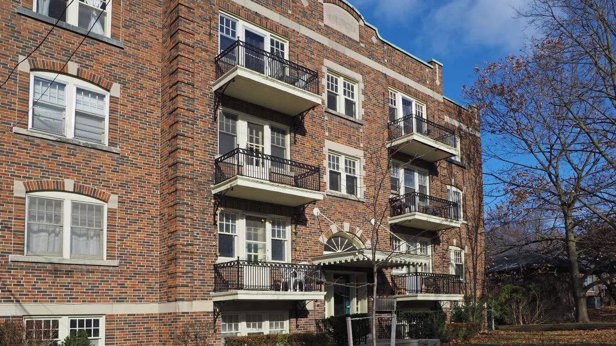 Older, four-story brick apartment building with balconies