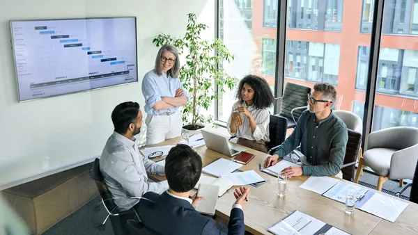 Diverse corporate team working together in modern meeting room office.