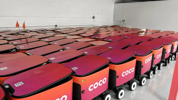 An image of a white room packed with pink and orange robots.
