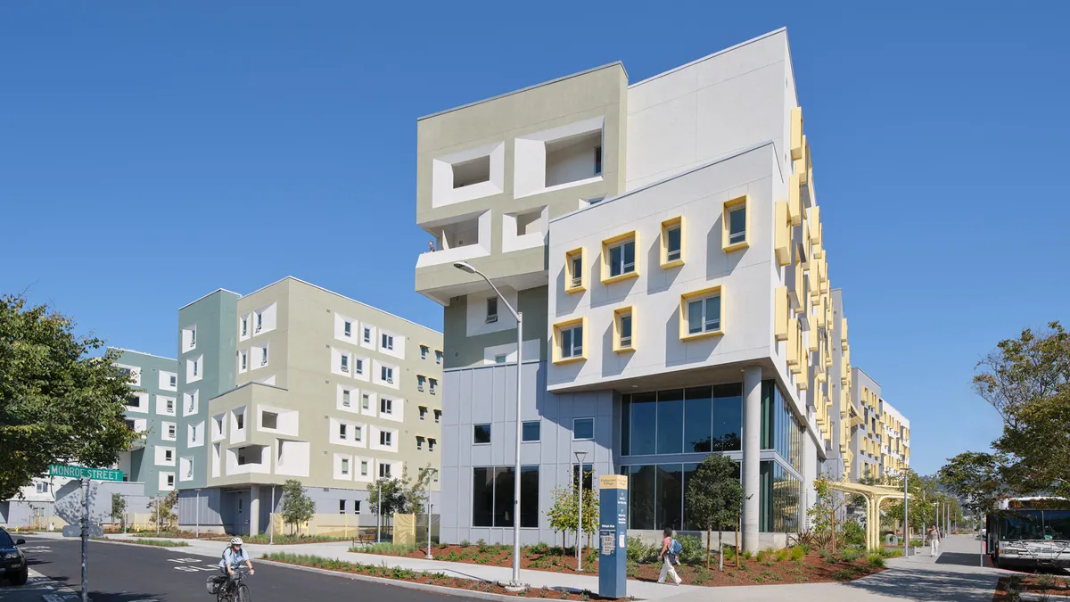 A mid-rise white building with angled windows.