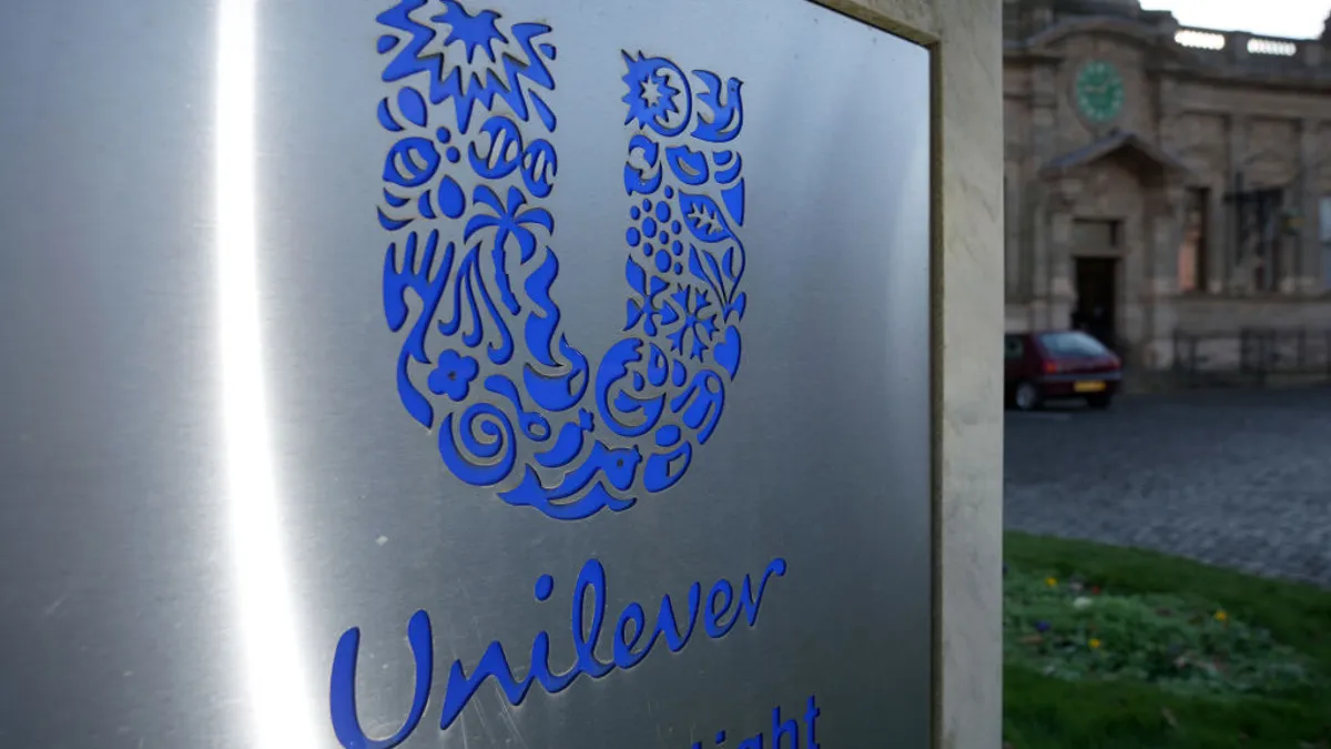 corporate signage in silver and blue outside of a factory entrance