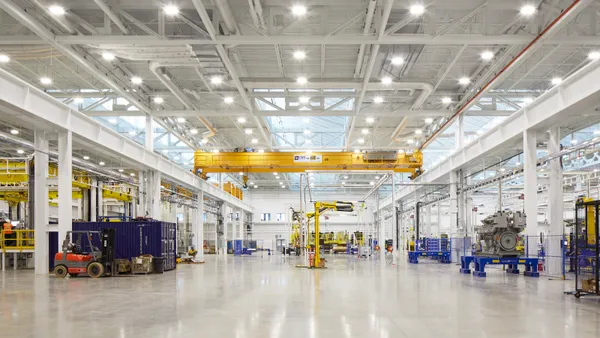 The interior shot of a very neat, white, sterile manufacturing environment, with machines scattered throughout the frame.