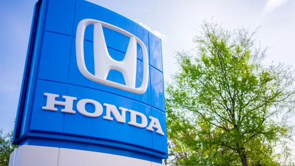 The honda logo is displayed on a sign at a dealership.