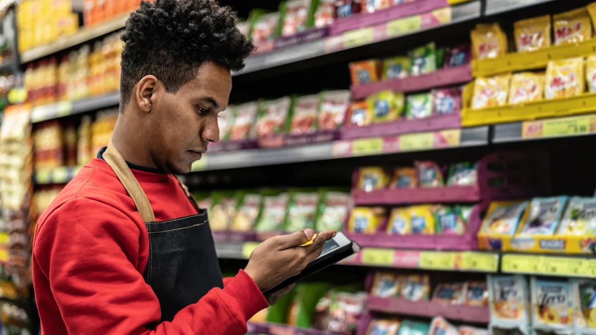 Worker checking inventory in a digital tablet at a supermarket