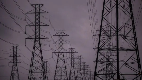 Transmission towers against a dark sky