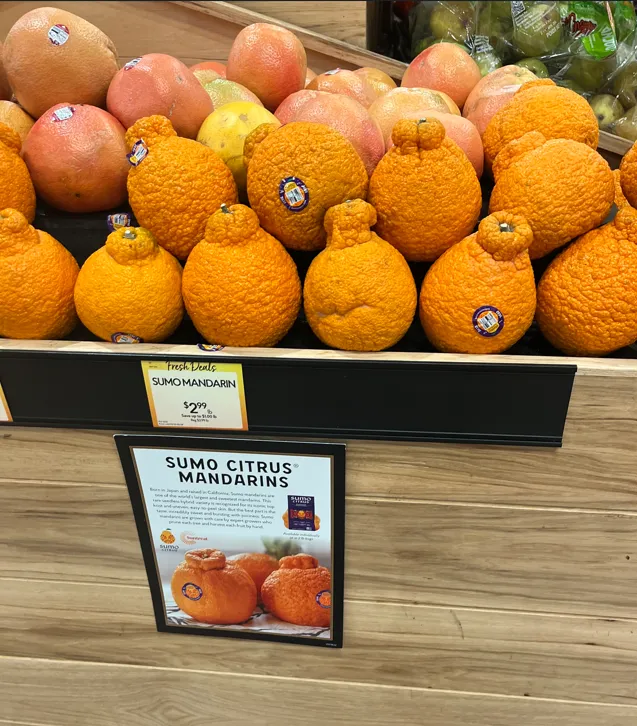 A display of sumo citrus mandarins in a grocery store.