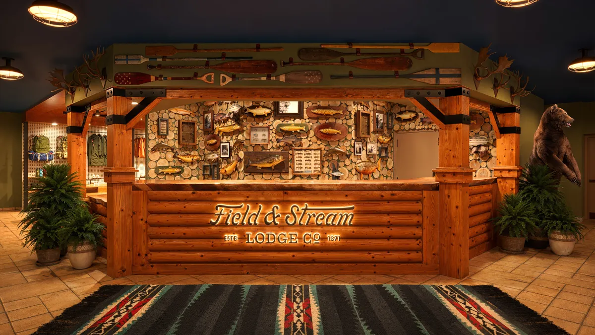 A wooden front desk displays the Field and Stream logo.