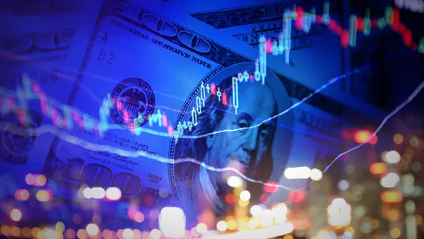 A candlestick stock chart is seen out of focus against a background of $100 dollar bills in this composite stock image.